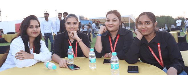Group of female colleagues wearing ID lanyards, enjoying outdoor event