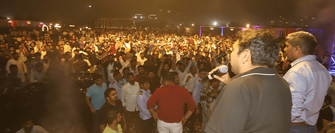 Crowd gathered in front of stage during a lively night event or concert